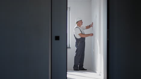 el electricista instala y comprueba las tiras de led para la iluminación en el apartamento. enciende y comprueba la luz y las luces decorativas