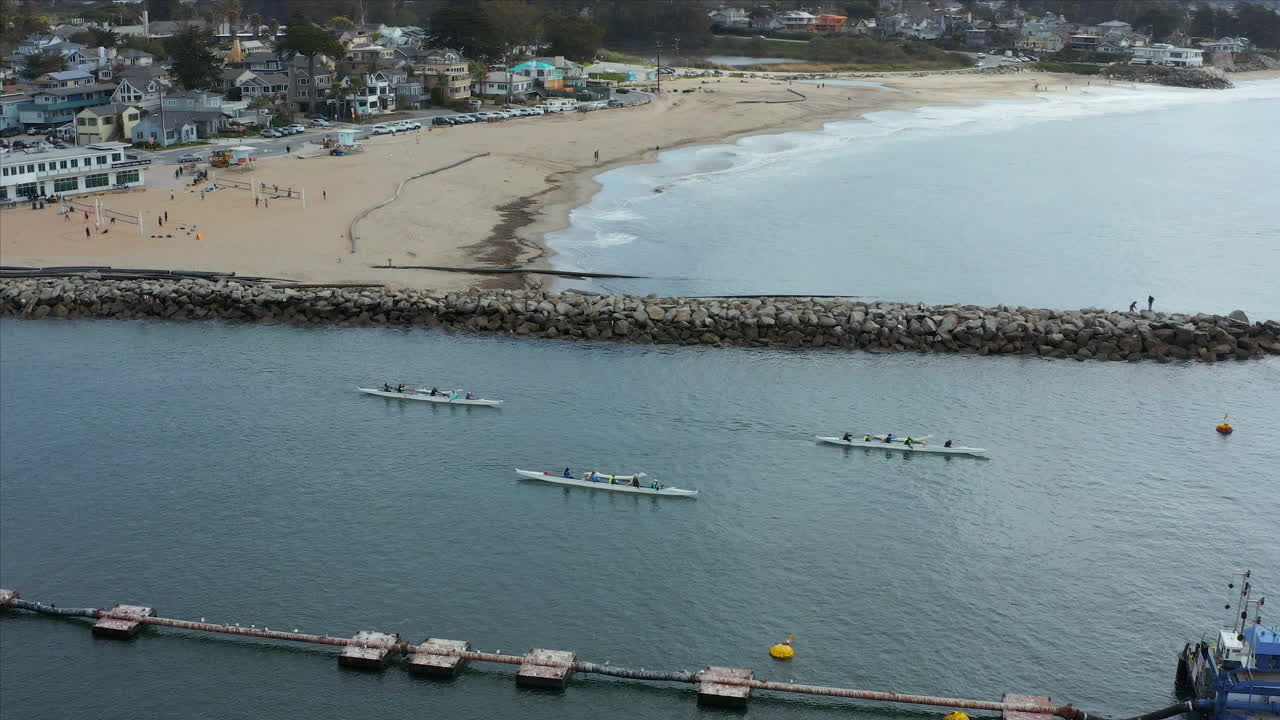 Ripresa aerea con drone in tracking di una gara di canoa al largo della costa di Santa Cruz, California, USA.