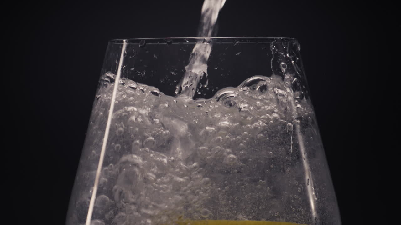 agua vertiendo limón menta bebida vaso de primer plano. preparación de concepto de cóctel