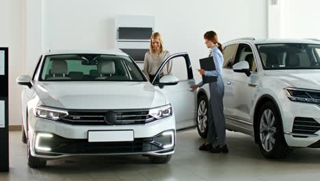 car salesperson showing car to customer in dealership