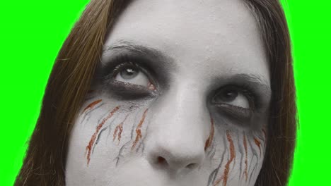 the rehearsal - teenage girl, disguised for halloween or a costume party, is rehearsing to appear scary - shot against a green screen