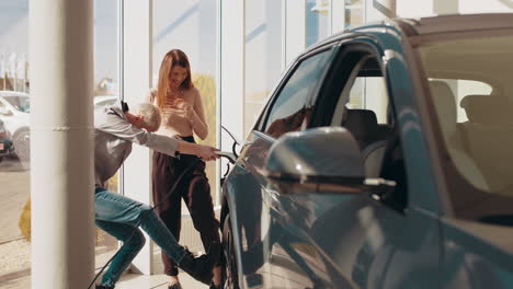 una pareja feliz probando un coche eléctrico.