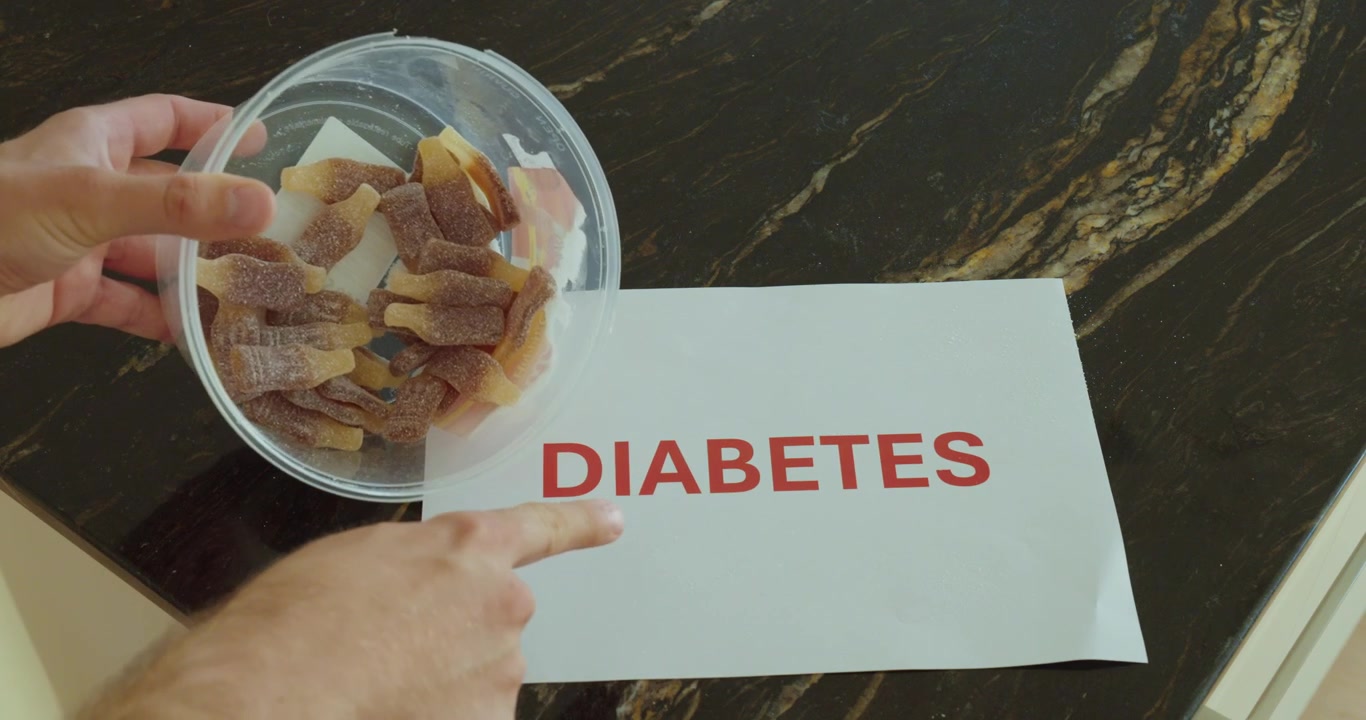 Hænder viser sukkerholdigt slik ved siden af diabetes-tekst, repræsenterer sundhedsrisici og sukkerbevidsthed