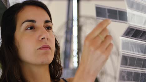 female photographer checking film strips at photo studio 4k