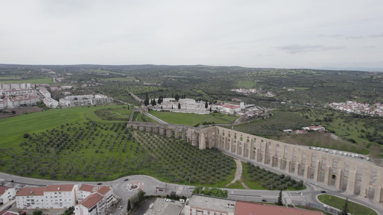 aerial above Amoreira Aqueduct spanning green hills and town of Elvas Portugal