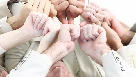 Business-team-on-floor-in-a-circle-with-thumbs-up