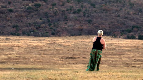 lady fishing in an emerald gown by a pond, enjoying the serene and scenic rural setting