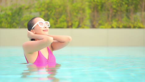 A-pretty-young-fit-woman-in-a-swimming-pool-pushes-her-wet-hair-from-her-face