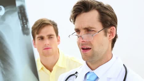 Doctor-Mirando-Radiografía-Con-Paciente-Y-Asintiendo
