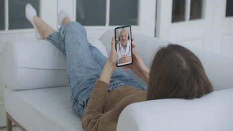 Mujer-Que-Usa-Una-Aplicación-Médica-En-Un-Teléfono-Inteligente-Consultando-Con-Un-Médico-A-Través-De-Videoconferencia.-Mujer-Que-Usa-Chat-En-Línea-Para-Hablar-Con-Un-Terapeuta-Familiar-Y-Verifica-Posibles-Síntomas-Durante-La-Pandemia-De-Coronavirus