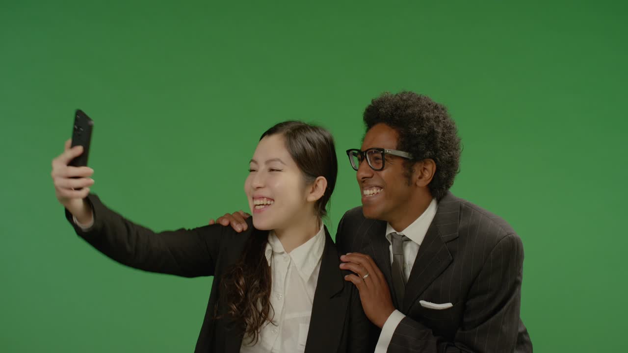 녹색 화면에서 셀카를 찍는 행복한 동료