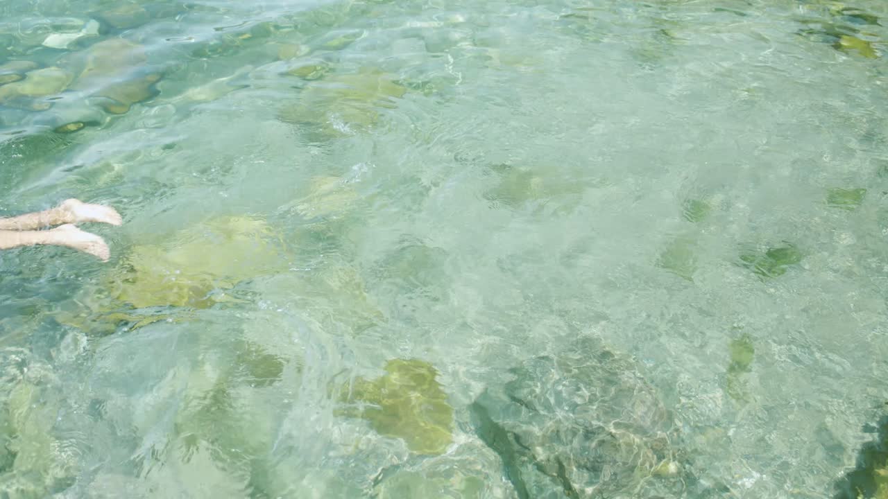 남자는 alentejo의 포르투갈 바다에서 수정처럼 맑고 푸른 바다로 다이빙합니다.