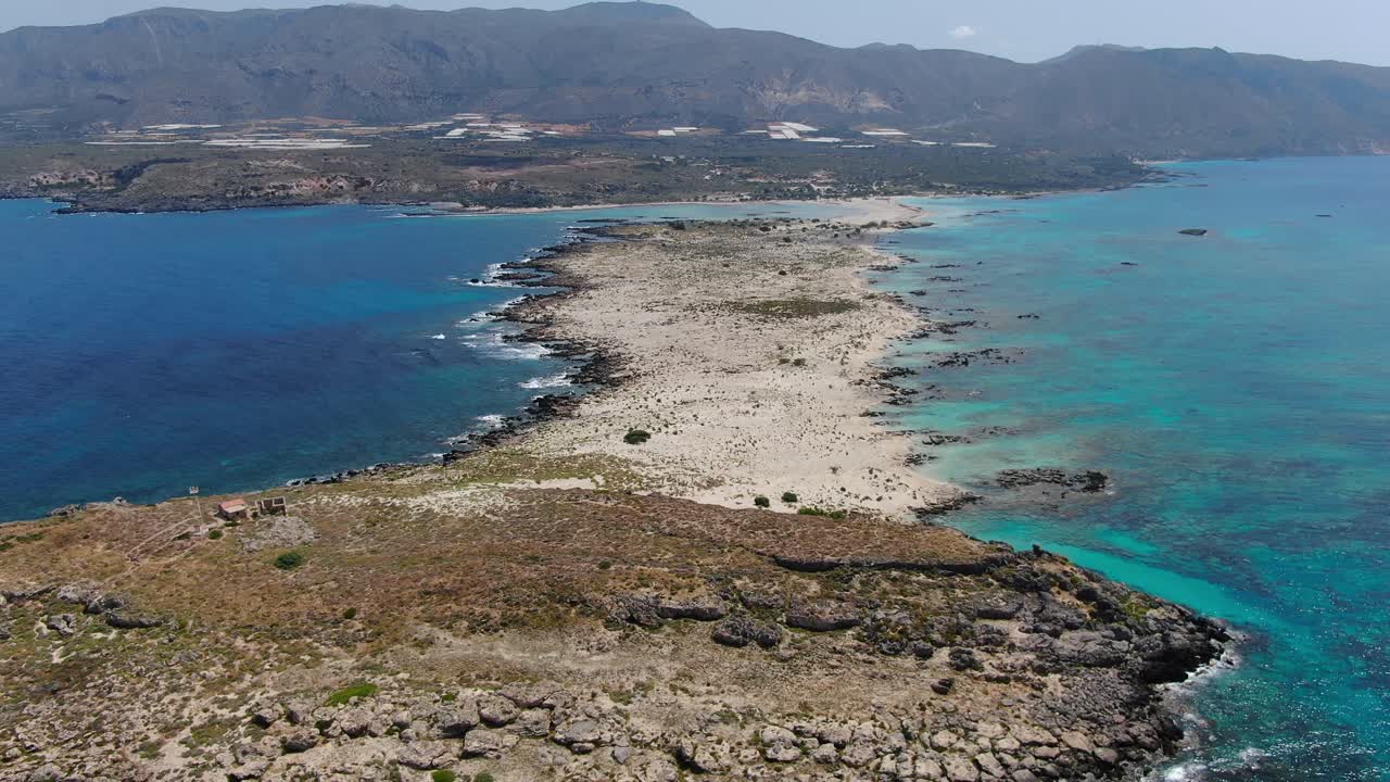 Elafonissi Beach peninsula in Crete Greece full view with Church Agia Irini right, Aerial dolly out reveal shot