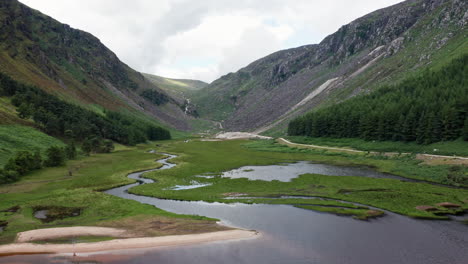 Stunning-Aerial-Shot-of-Glendalough-Upper-Lake-in-Wicklow-Mountains-National-Park-in-Ireland