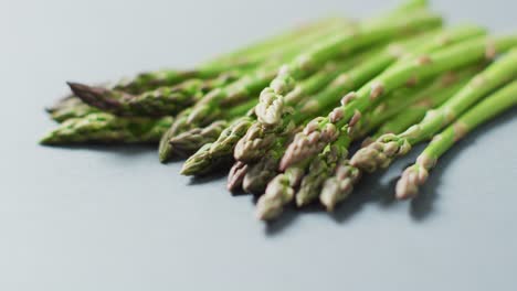 Video-of-close-up-of-fresh-asparagus-over-grey-background