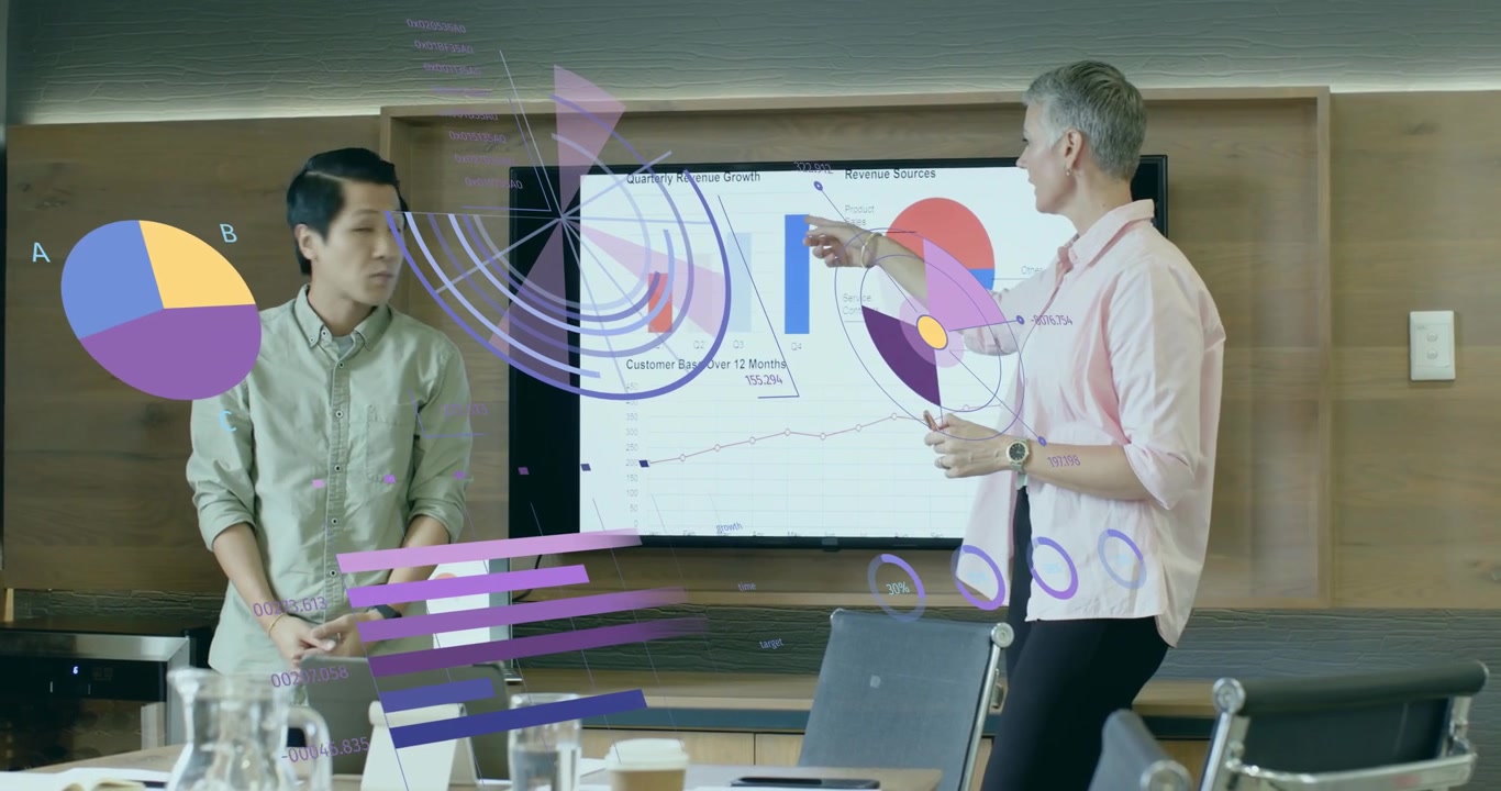 Presenter gesturing charts in business meeting while colleague highlighting line graph trends