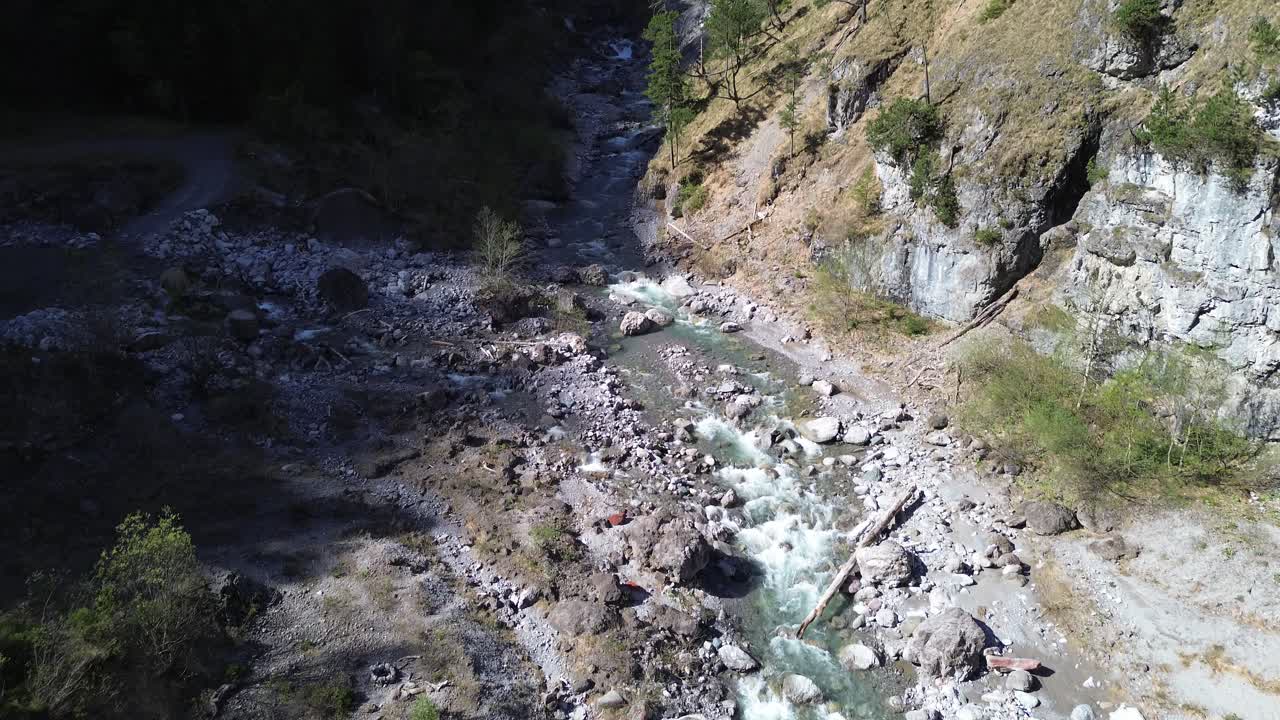 un dron vuela sobre un río con aguas cristalinas de color turquesa en un valle montañoso en austria, europa