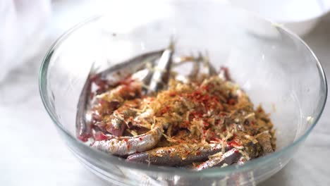 add-the-spices-to-the-bowl-of-sardines