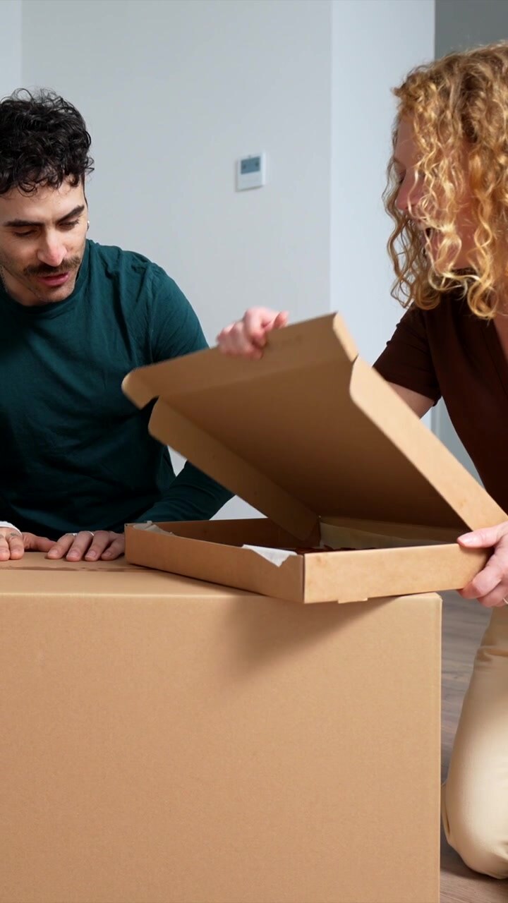 Family Opening Pizza Box While Moving Into New Home