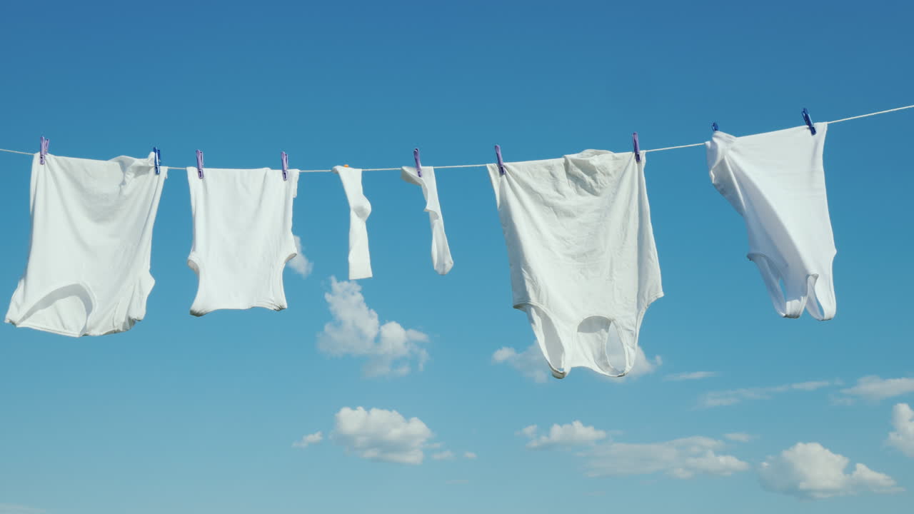 하얀색 리넨은 푸른 하늘 배경 4k 비디오에 밧줄로 말린다