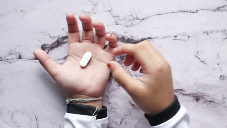 hands holding a white pill