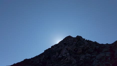 Hiker-in-distance-back-lit-revealed-slow-motion-pan-Kananaskis-Alberta-Canada