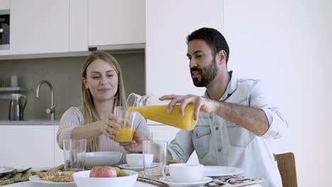 Family-couple-sitting-at-dining-table-with-dish