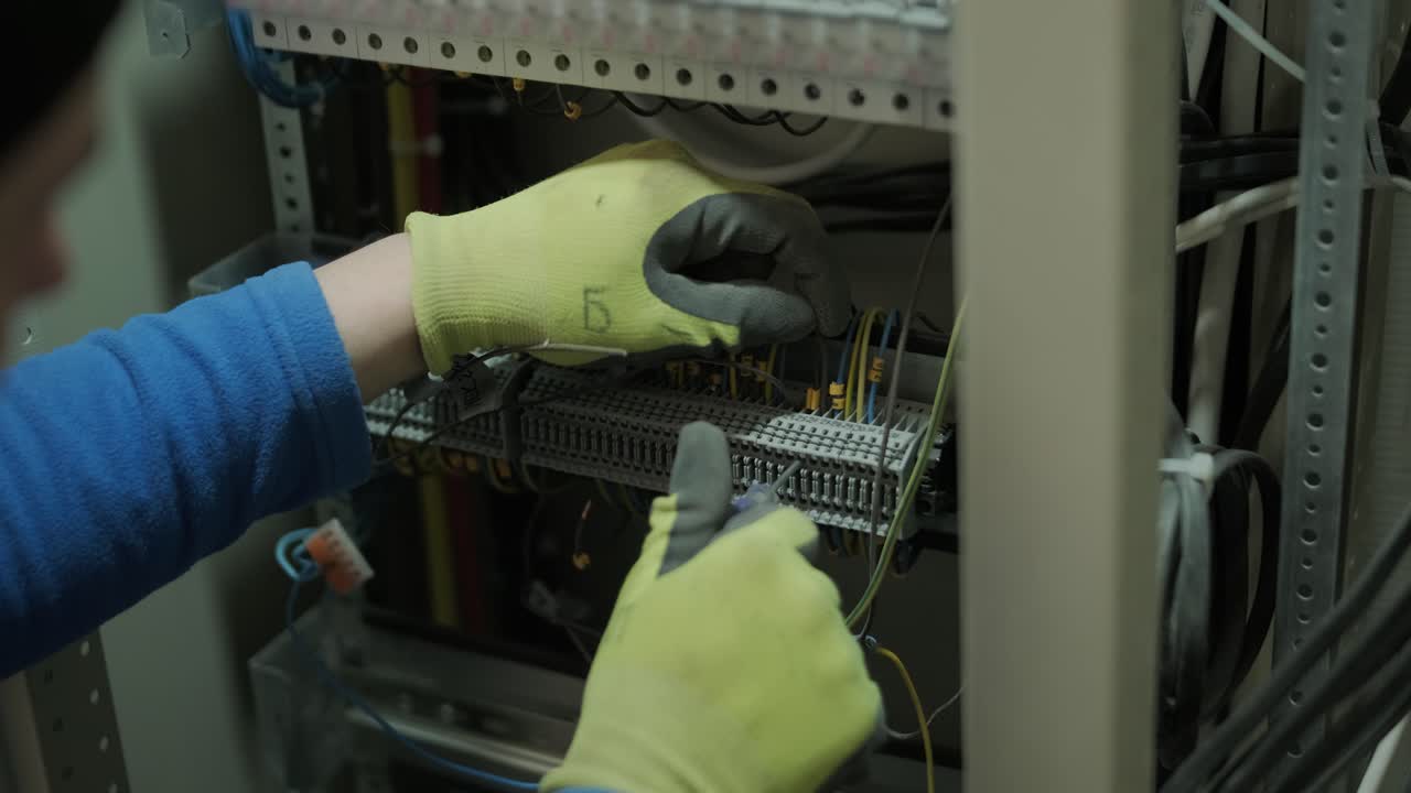 electricista trabajando en interruptores dentro del panel de control