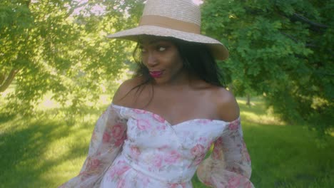 mujer negra sonriendo en un picnic en el parque mirando hacia arriba inclinado