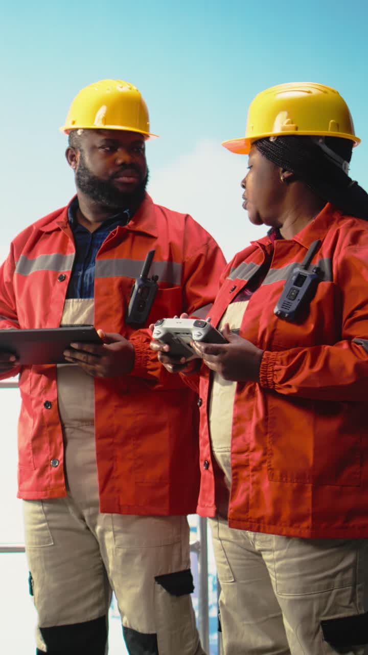 Vertical video Drilling rig engineering team using drone to access dangerous areas