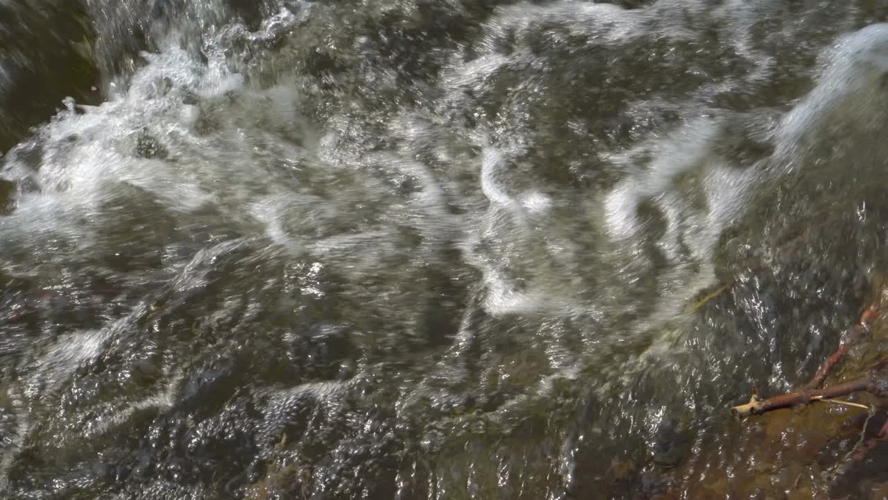 The rapid flow of water in the river after rain on a summer day. Close-up of the swirls. Top view. 4K.