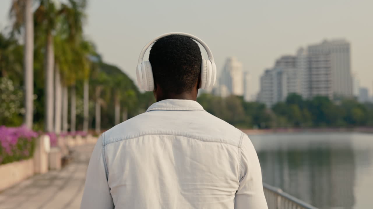 Man Walking in Park with Headphones