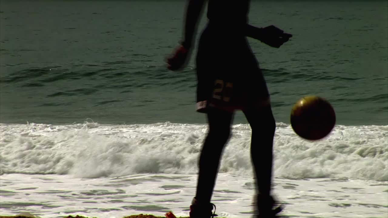hombre practicando fútbol en la playa de nigeria