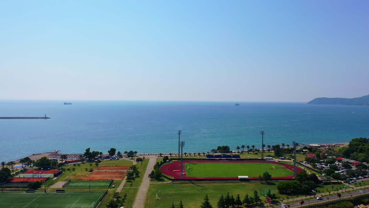 Approaching the beautiful waterscape of Adriatic Sea. Drone footage above the green area at the shore.