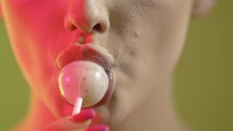 mujer lamendo helado con seducción, boca en primer plano sobre fondo verde