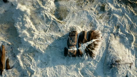 White-Waves-On-Sea-Rocks-At-Camps-Bay,-Cape-Town,-South-Africa---aerial-top-down