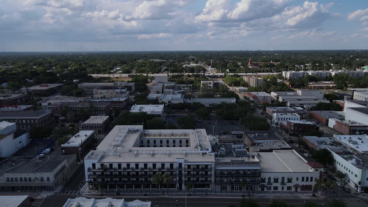 aerial of north Ybor City with a perfectly timed large bird flying past the camera in Tampa, Florida