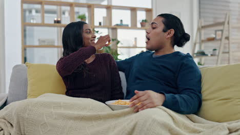 Popcorn,-playful-and-couple-on-sofa-in-home