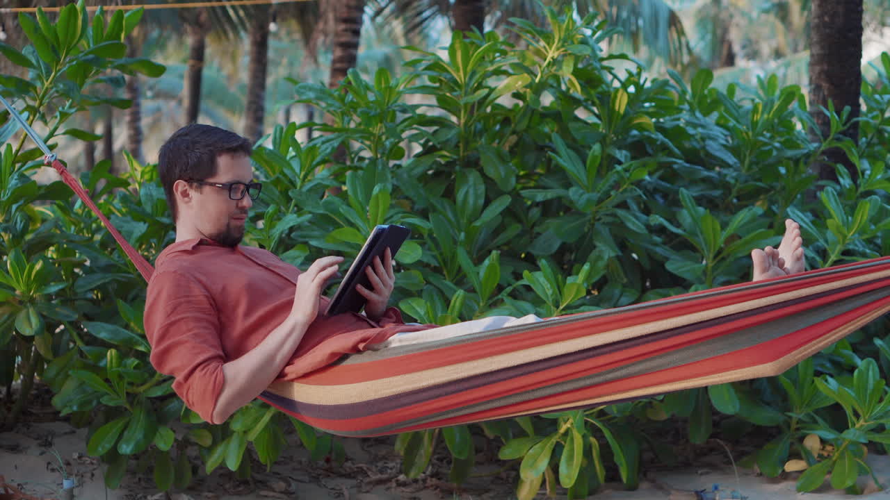 hombre relajándose en una hamaca en una playa tropical