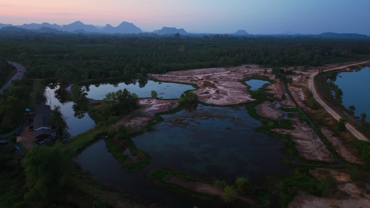 Sunrise/Sunset over a rural landscape with roads, water bodies, and mountains in the distance