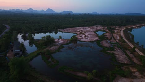 sunrise/sunset over a rural landscape with roads, water bodies, and mountains in the distance