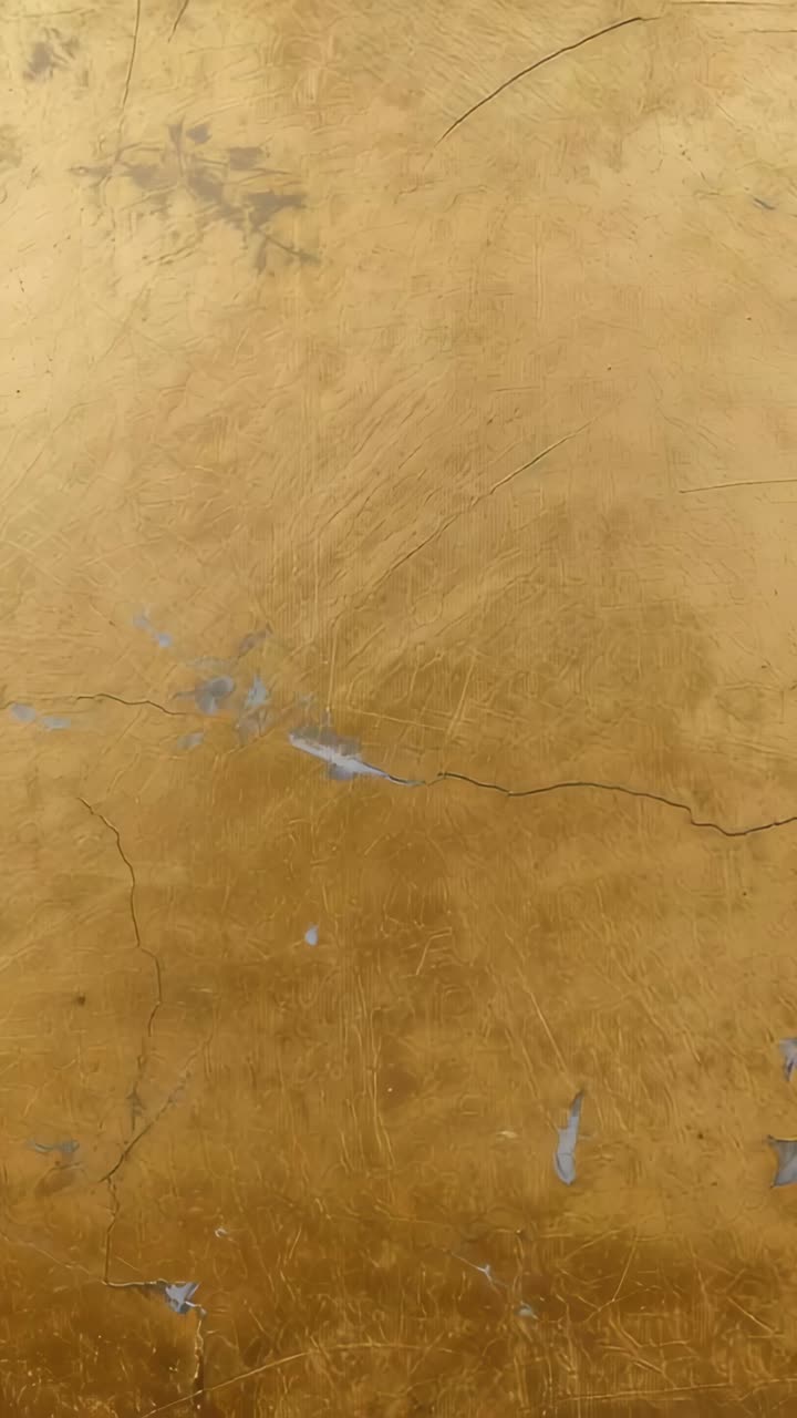 Vertical video: Holding camera framing golden wall in interior to document fine cracks and smudges