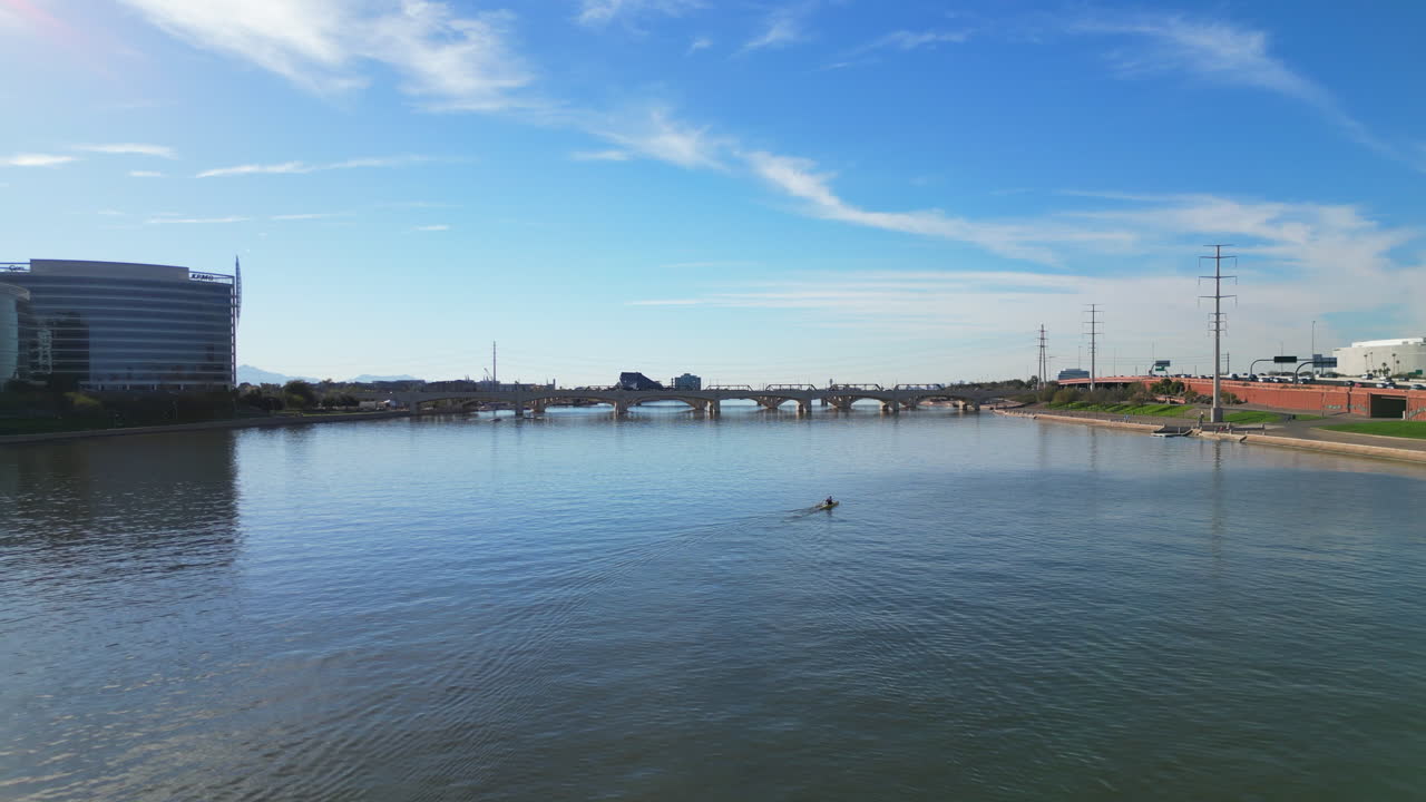 A man paddling his paddle boat on Tempe Town Lake located in Tempe Arizona just outside of Phoenix