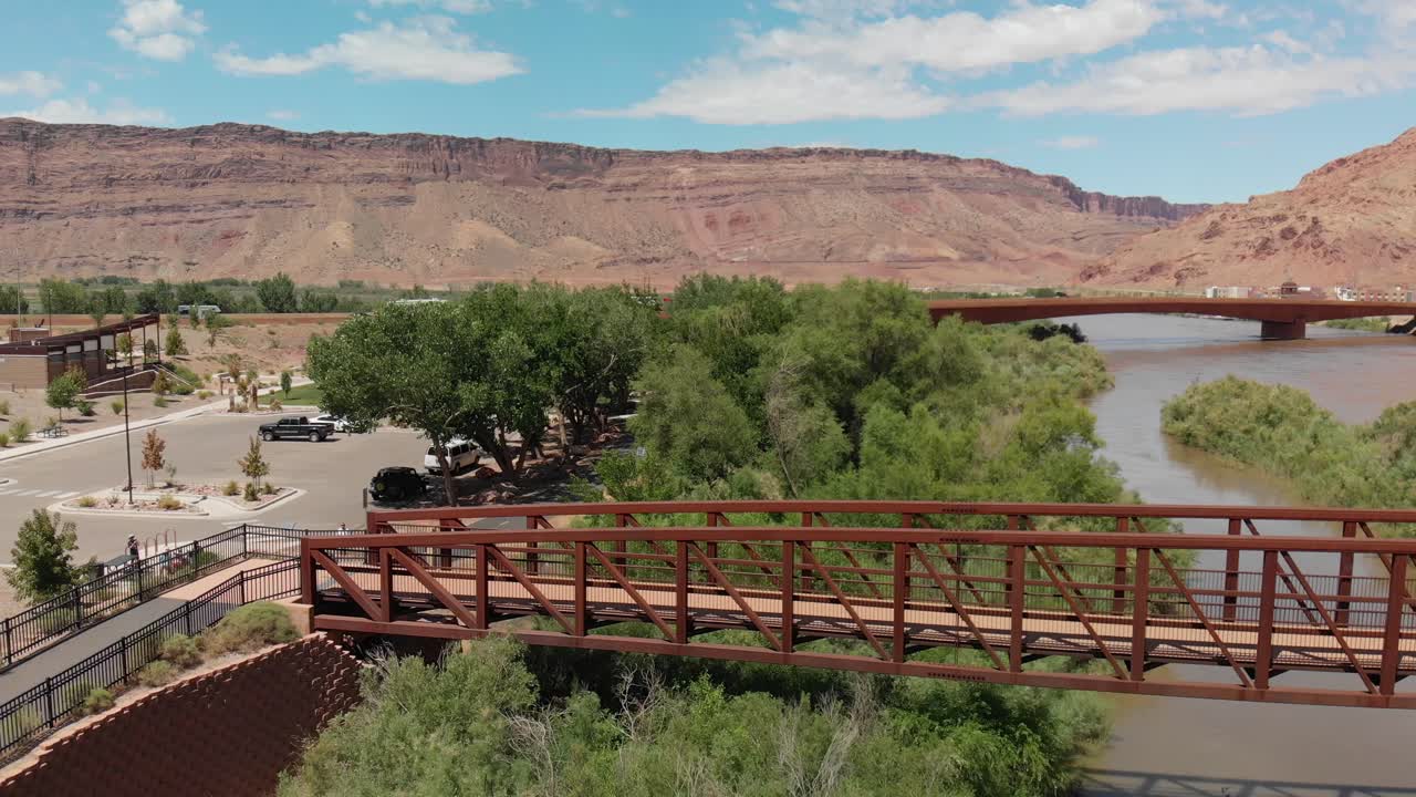 Aerial of pedestrian bridge over the Colorado River near Moab, and in distance visible Bridge of US 191 - stands as a testament to engineering and nature's majesty