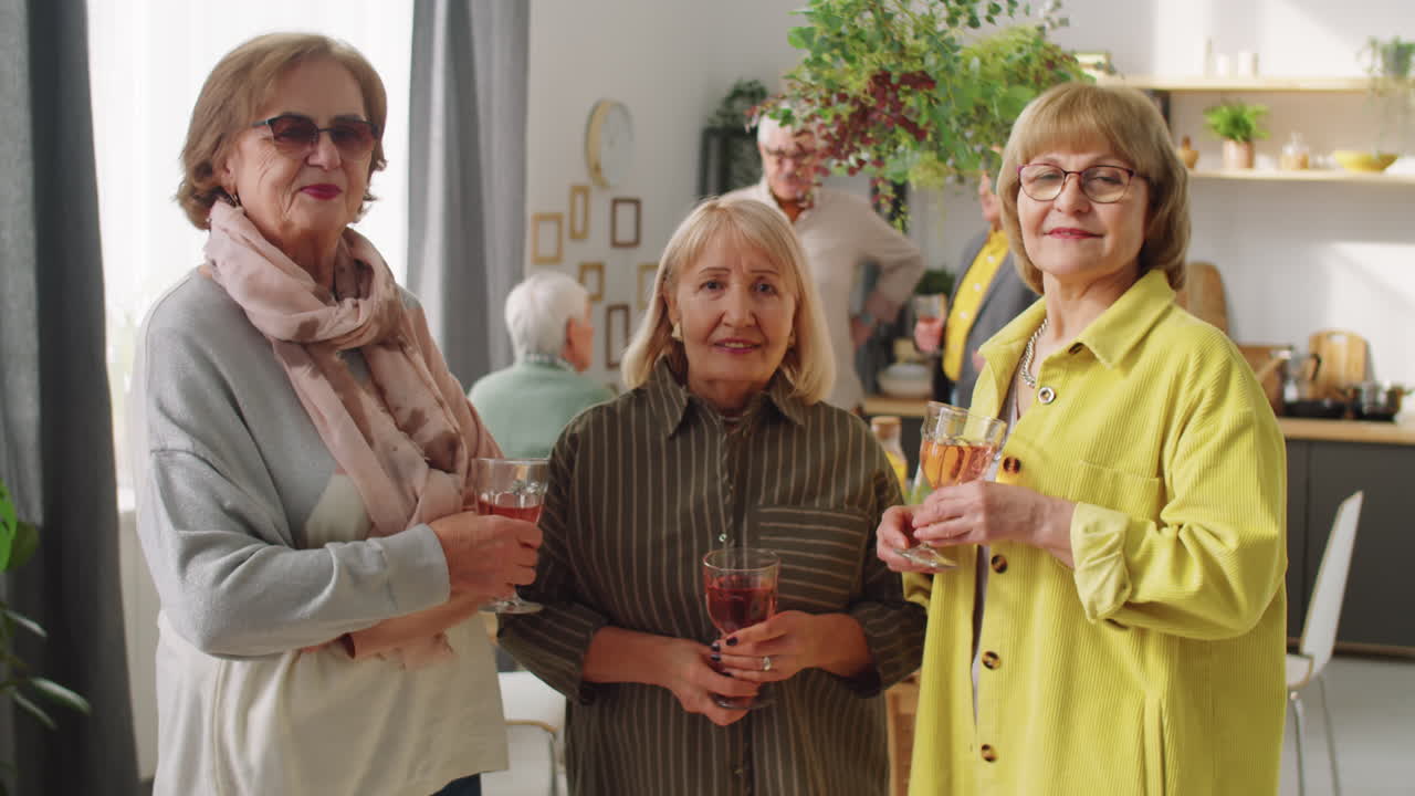 Portrait of Happy Elderly Women with Drinks at Home Party