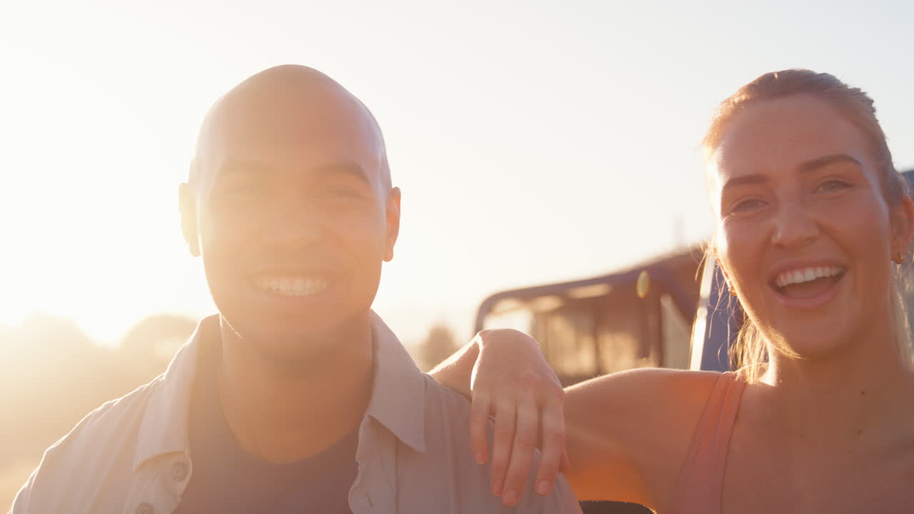 retrato de amigos sentados en la puerta trasera de una camioneta en un viaje por carretera a la cabaña en el campo