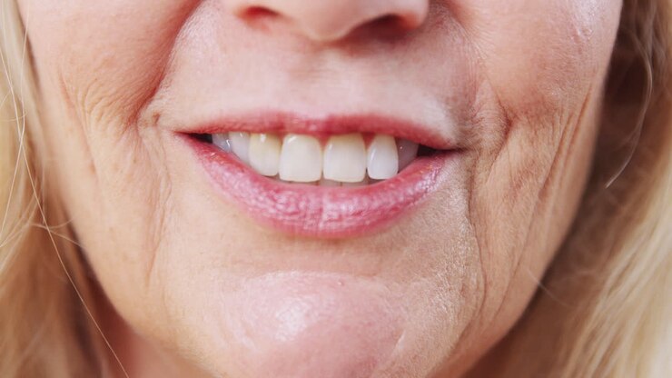Close Up Of Mouth Of Mature Woman As She Talks To Camera In Studio