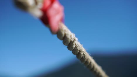 Detail-of-nautical-rope-with-sky-and-scenery-in-background