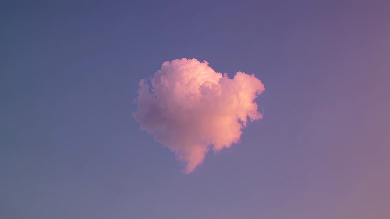 A heart-shaped cloud floats in a pastel sky, captured from a low-angle