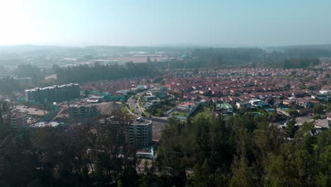 Dolly-in-aerial-view-of-a-condominium-of-similar-houses-in-the-forest-of-Curauma,-Chile